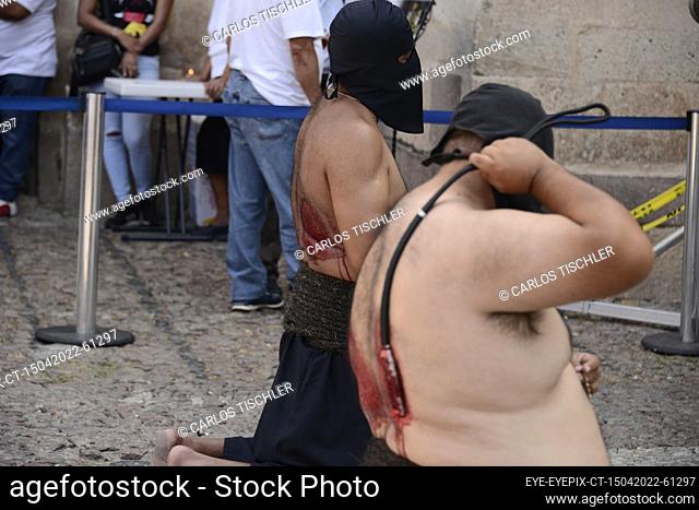 TAXCO, MEXICO - APR 15, 2022: A ‘E’ncruzado’ penitent wears a black hood known as a capirotte, while he flagellates himself