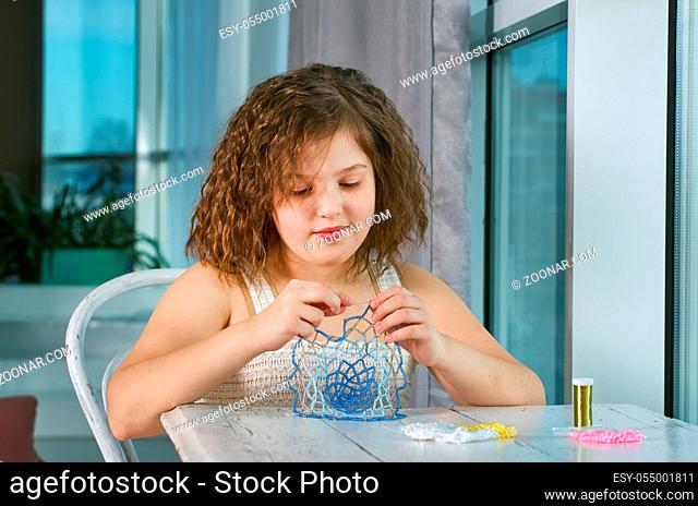 Little girl making jewelry, handicraft beads