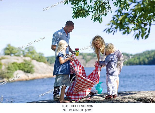 Family preparing for picnic beside lake