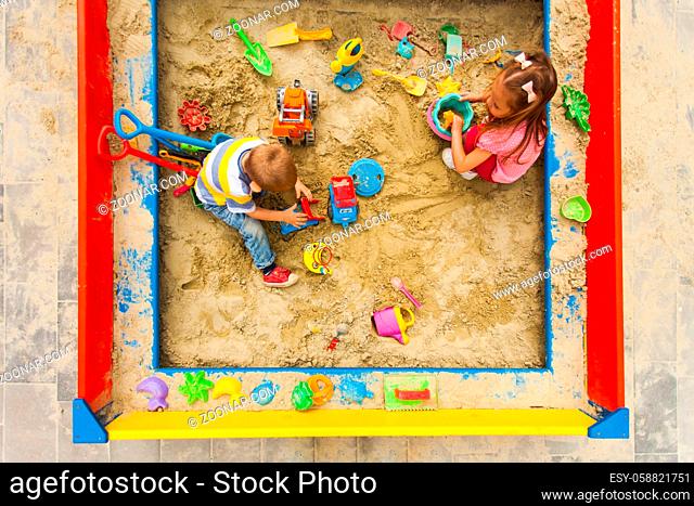 Kids having fun in big modern sandbox outside