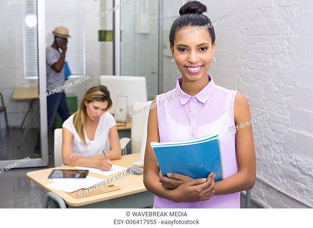 Casual woman with colleague behind in office