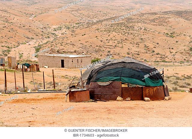 Kuboes settlement, traditional domed hut of the local Nama people in the front and a modern brick house at the back, Richtersveld desert landscape, South Africa