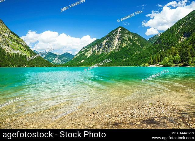 Lake Heiterwanger See on a sunny summer day. Alpine mountain landscape with mountain lake and forests. Tyrol Zugspitz Arena, Tyrol, Austria, Europe