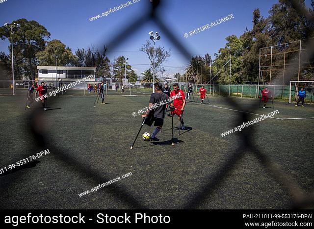 10 October 2021, Mexico, Mexiko-Stadt: Two teams compete for a ball during a tournament for young amputees. Young amputees held a soccer tournament in Mexico...