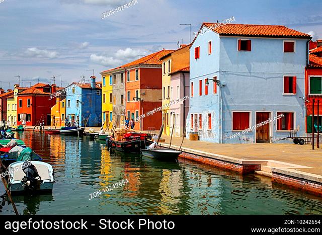 Colorful houses by canal in Burano, Venice, Italy. Burano is an island in the Venetian Lagoon and is known for its lace work and brightly colored homes