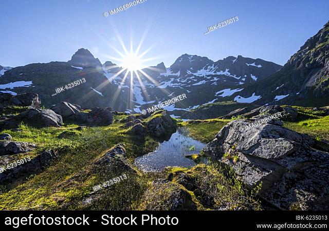 High moor, sun shining on mountains with snow, mountain range at Trollfjord Hytta, at Trollfjord, Lofoten, Nordland, Norway, Europe