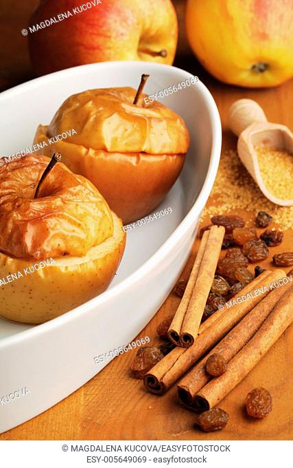 Baked apples in white bowl and ingredients