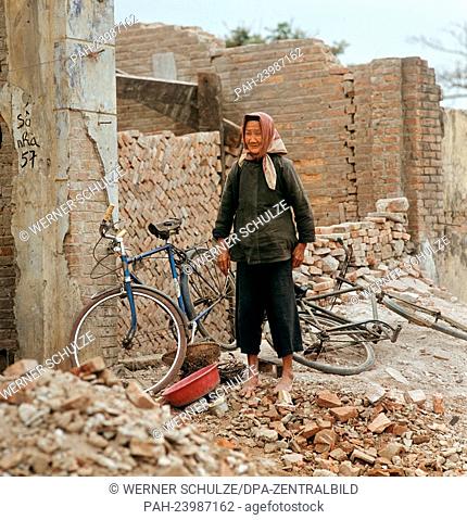 An older Vietnamese woman is standing in the ruins of houses, which were damaged during the war, in Hanoi, North Vietnam, in spring 1973