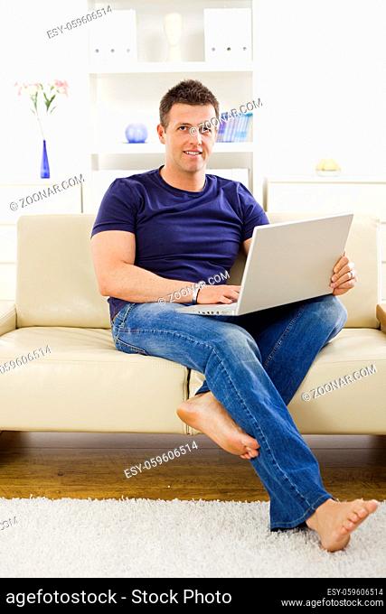 Man browsing internet on laptop computer at home