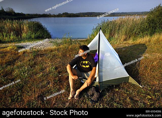 Hiker, man in front of a tent at the Stresower See in the Wrechower Aue, nature reserve Aland-Elbe-Niederung, UNESCO biosphere reserve Flusslandschaft Elbe