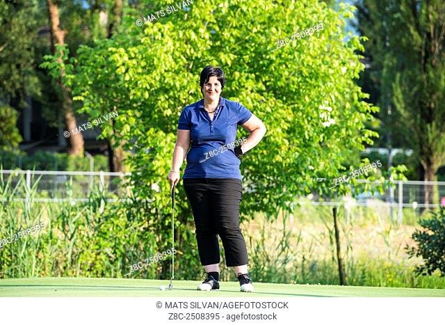 Happy and proud woman playing golf in Ticino, Switzerland
