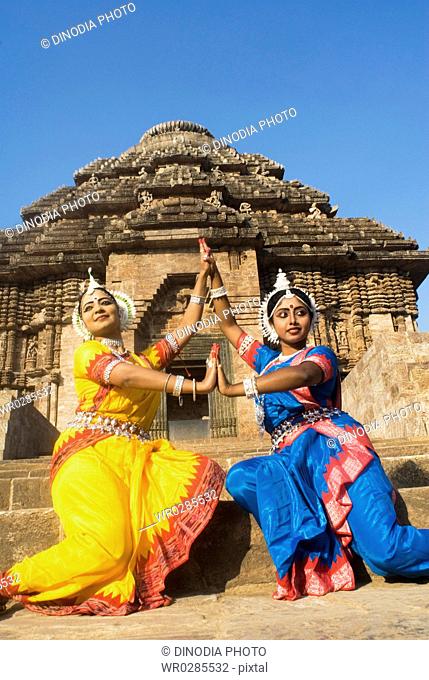 Odissi dancers strike pose re-enacts Indian myths such as Ramayana in front of world heritage Sun temple complex in Konarak , Orissa , India MR400