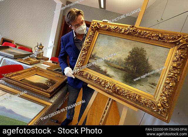 25 March 2022, Saxony-Anhalt, Wernigerode: Museum director Christian Juranek looks at paintings submitted by visitors. Objects like these paintings will be the...