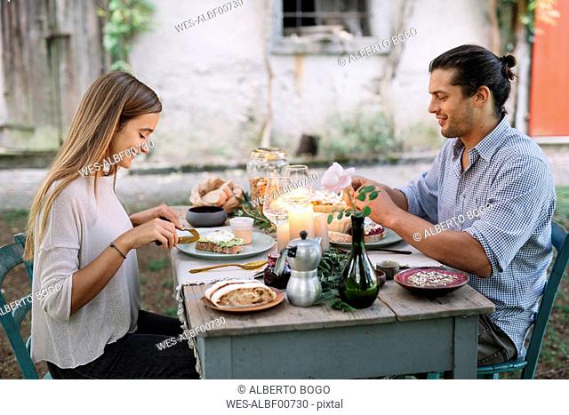 Couple having a romantic candlelight meal next to a cottage