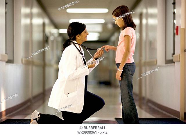 Young girl playing with female doctors stethoscope