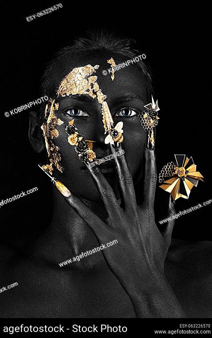 Beautiful woman with black art make-up, creative long nails. Design manicure. Beauty face. Picture taken in the studio