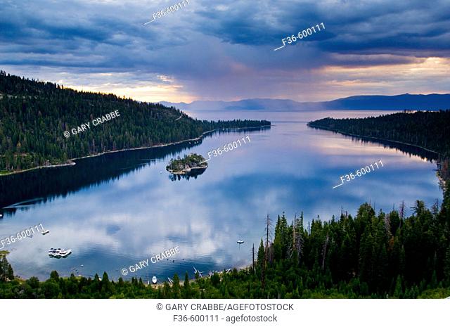 Rain storm clouds at sunrise over the still waters of Emerald Bay State Park, South Lake Tahoe region, California