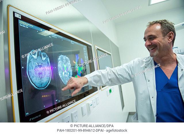 Bernhard Meyer, director of the neurosurgery clinic, swipes a human brain's profile on a computer screen during the inaugural press conference at the clinic...
