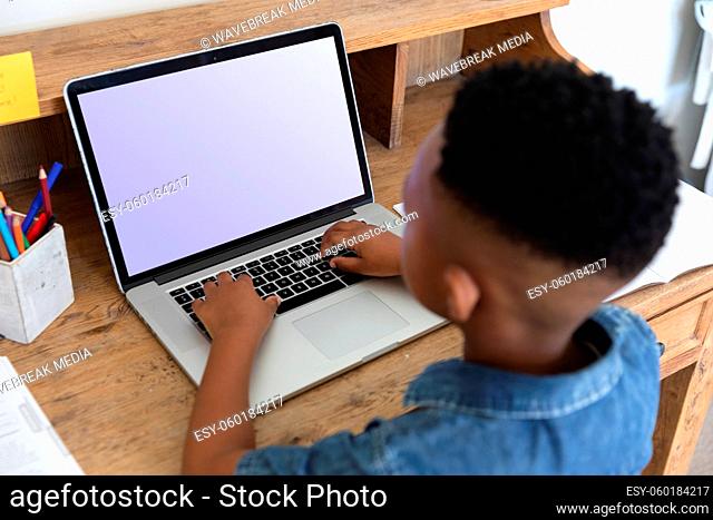 African american boy having video call using laptop during class at home