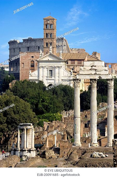 View of The Forum with the Colosseum rising behind the bell tower of the church of Santa Francesca Romana with the Temple of The Vestals and the three...