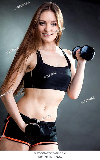 Fitness girl training shoulder muscles lifting dumbbells