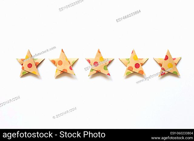 Colorful dot pattern brown five stars quality rating on white background. top view