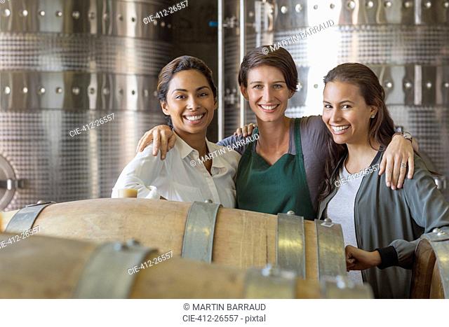 Portrait smiling women in winery cellar