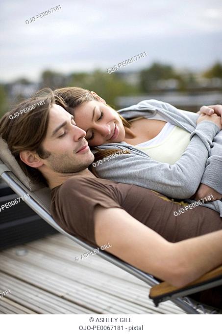 Couple laying in lounge chair together