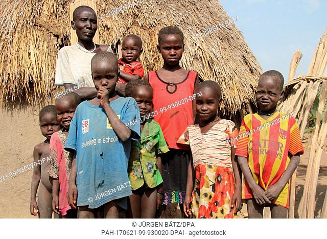 Internally displaced Nyakume Wuor Gai stands together with her own children and neighbour's children in front of a shed on an island near Nyal at the federal...
