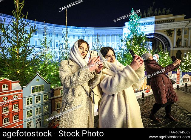 RUSSIA, ST PETERSBURG - DECEMBER 20, 2023: Young women take pictures during a ceremony to light up the main Christmas tree of St Petersburg in Palace Square