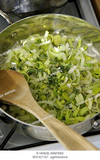 Sweating leeks and thyme in a sauteuse pan