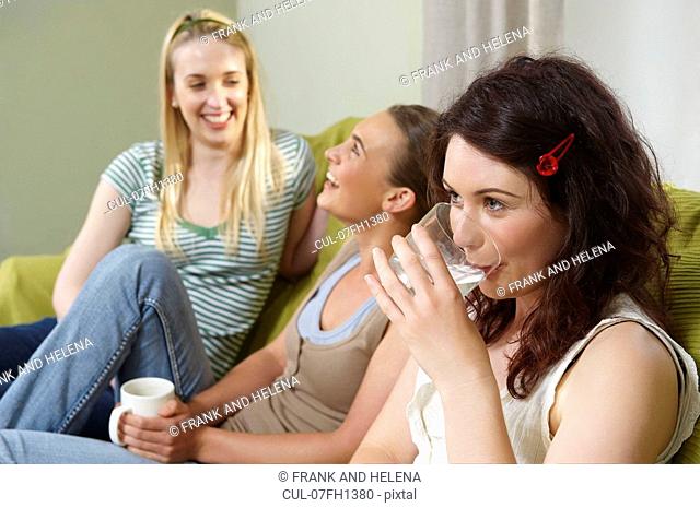 Three young women seated on couch