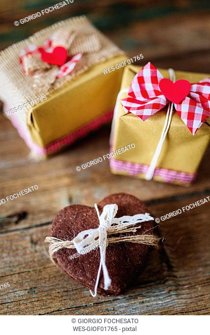 Stack of heart-shaped chocolate shortbreads tied with lace and two gift boxes