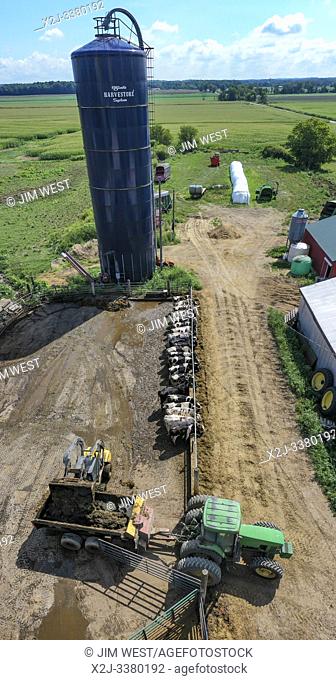 Three Oaks, Michigan - A farmer on a small, third generation dairy farm loads manure on a wagon to spread as fertilizer on a farm field