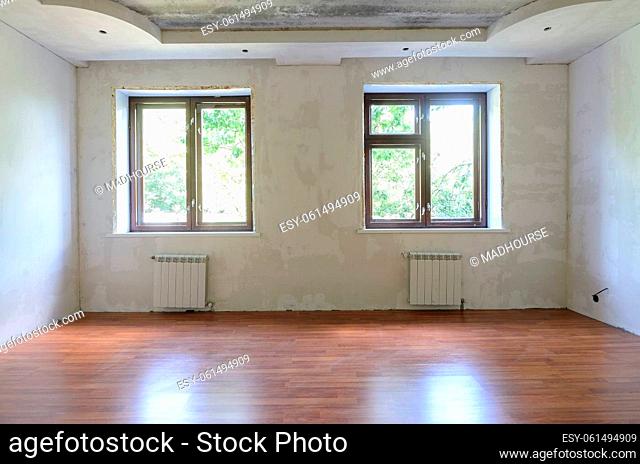 Interior of empty room during renovation, wall view with windows