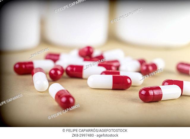 Pills spilling from an open bottle isolated on white background