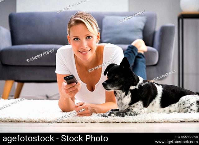 Woman Watching TV At Home With Dog