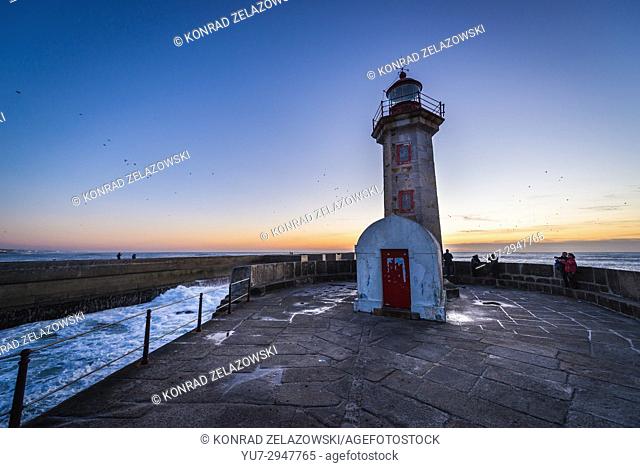 Sunset over Atlantic Ocean. View with Felgueiras Lighthouse (Farol de Felgueiras) on a breakwater of Foz do Douro district of Porto city