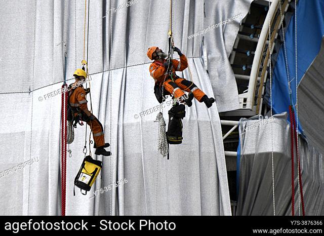 Workers install a shimmering wrapper to envelop Paris landmark, the Arc de Triomphe, in a posthumous installation by artist Christo on the Champs Elysee avenue...