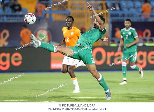 11 July 2019, Egypt, Suez: Cote d'Ivoire's Wonlo Coulibaly (L) and Algeria's Baghdad Bounedjah battle for the ball during the 2019 Africa Cup of Nations quarter...
