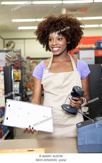 Portrait of an African American female store clerk standing at checkout counter