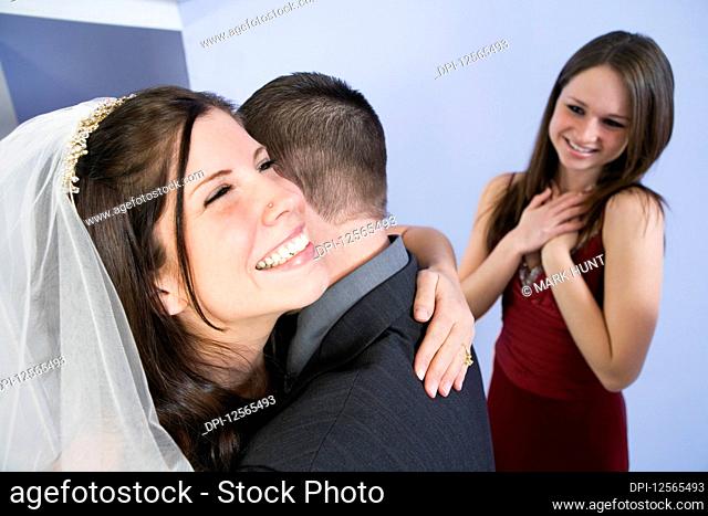 View of a cheerful bride hugging groom
