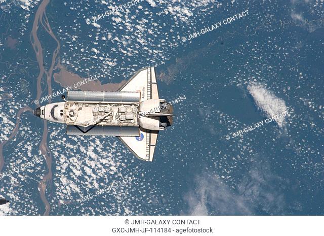 Backdropped by a colorful part of Earth, Space Shuttle Atlantis is featured in this image photographed by an Expedition 21 crew member as the shuttle approaches...