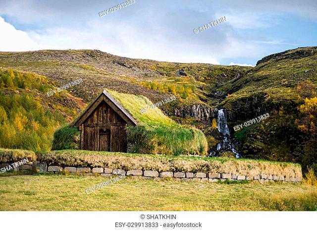 Antique traditional icelandic torf viking house near waterfall