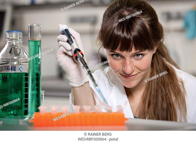 Germany, Bavaria, Munich, Scientist with pipette and test tubes in laboratory