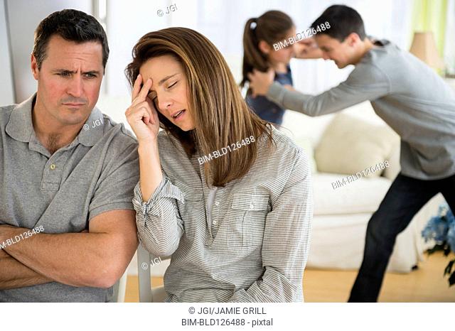 Frustrated Caucasian parents listening to children fight