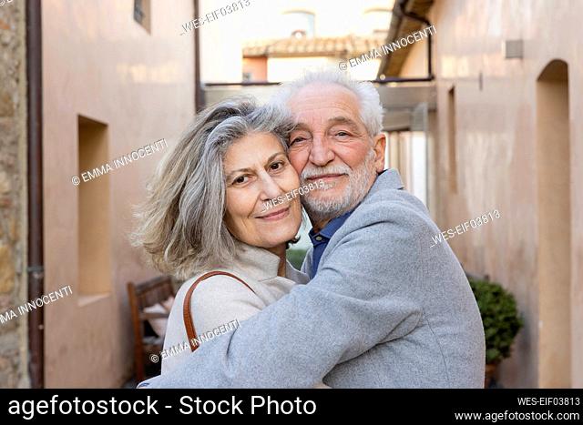 Happy senior couple embracing each other at hotel courtyard