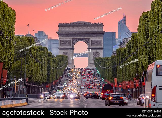 France. Paris. Dense traffic on the Champs Elysees. Triumphal Arch. Pink sunset