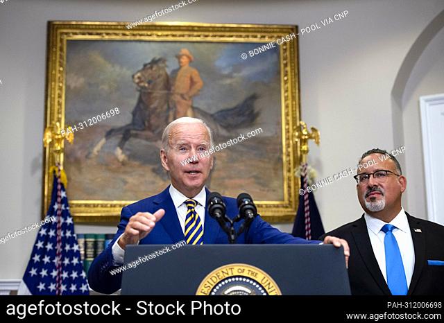 United States President Joe Biden gives remarks as US Secretary of Education Miguel Cardona looks on after Biden announced a federal student loan relief plan...