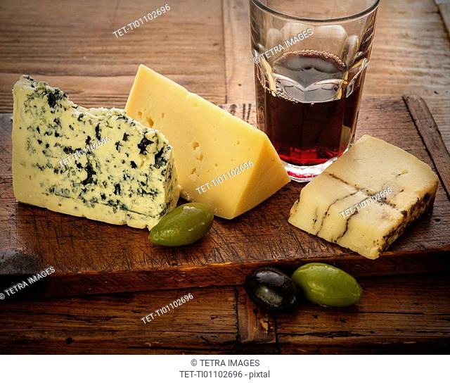 Assorted cheeses with olives and red wine